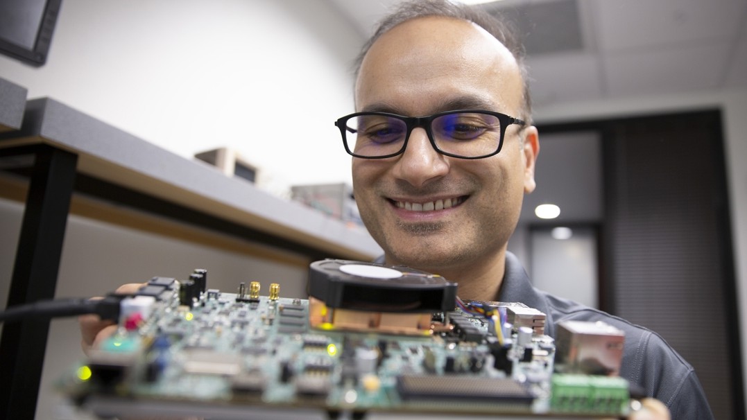 Aman Arora, an assistant professor of computer science and engineering in the School of Computing and Augmented Intelligence, part of the Ira A. Fulton Schools of Engineering at Arizona State University, inspects a field-programmable gate array, or FPGA, chip in his laboratory. 