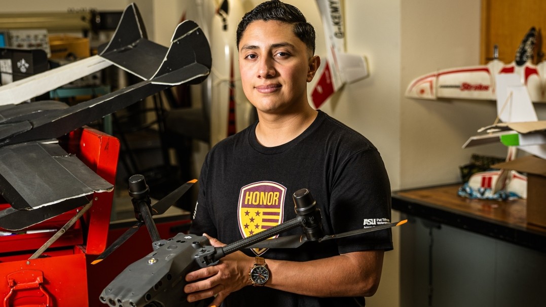 Naval reservist David Hernandez, a third-year aeronautical management technology student, is pictured holding some type of machine. He is using his GI Bill to earn a bachelor’s degree before returning to active duty with the U.S. Navy. 