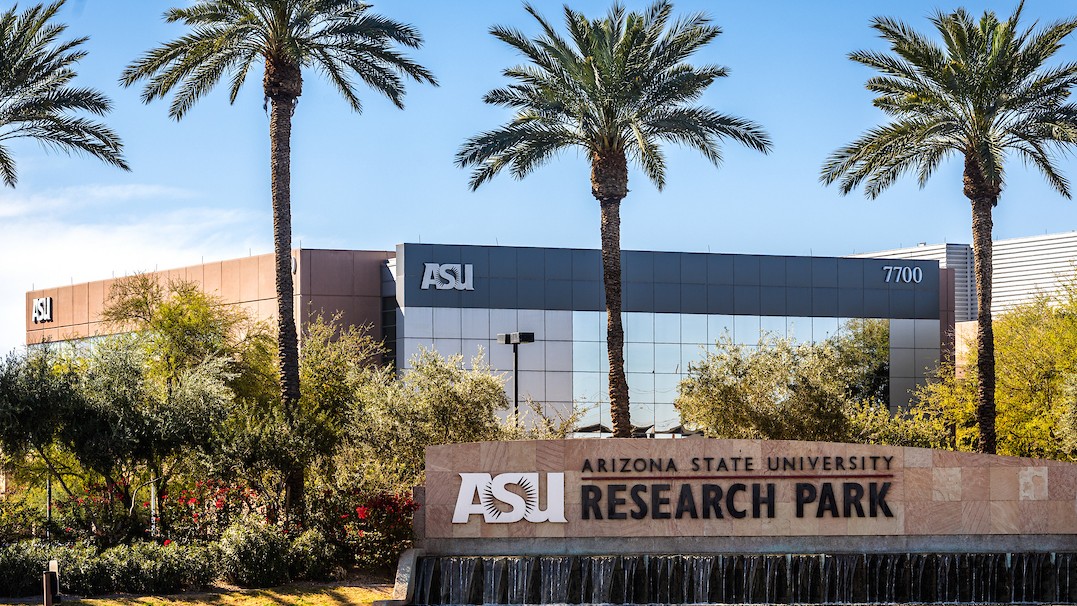 Photo of the ASU Research Park sign with a waterfall feature and buildings in the background 
