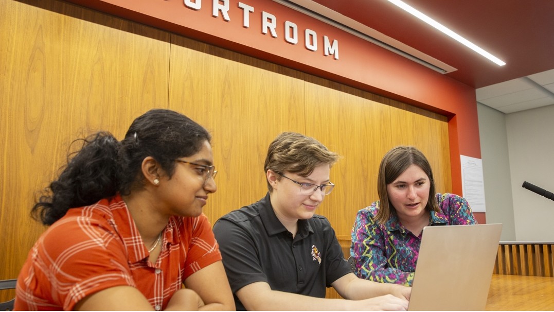diti Ganapathi, Easton Kelso and Ariadne Dimarogona work on a laptop in the J. Grant Woods Courtroom in Arizona State University’s Beus Center for Law and Society. 