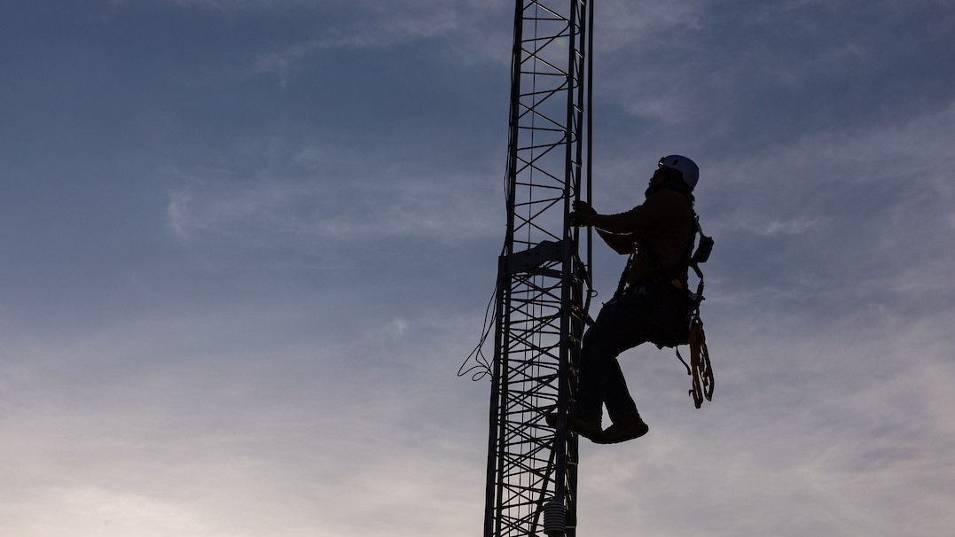 Photo of an ASU researcher climbing an eddy covariance tower to take heat measurements. 