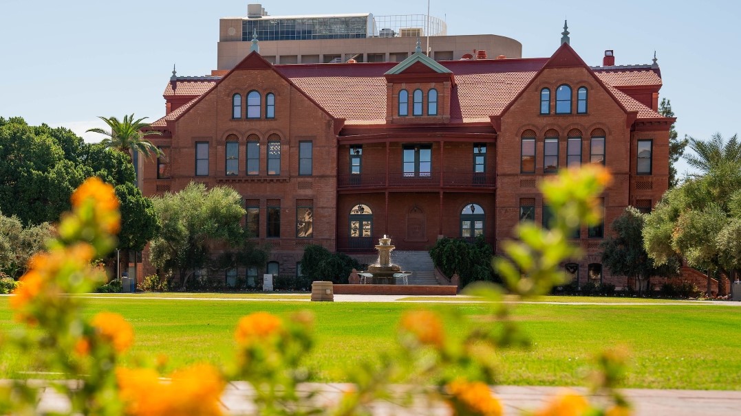 Photo of Old Main on the ASU Tempe campus with blurred flowers in the foreground 