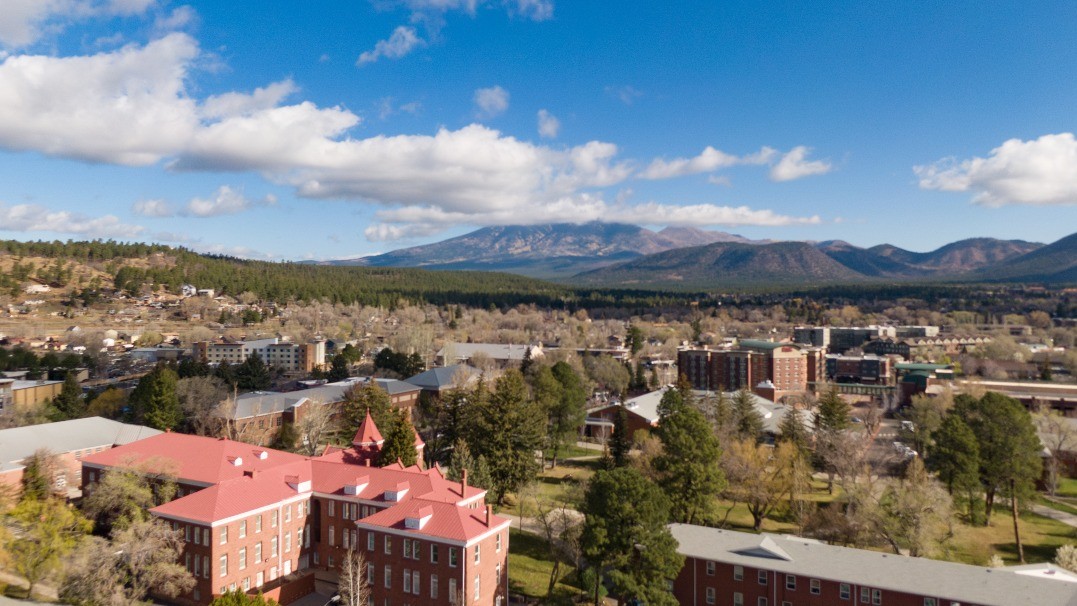 Aerial view of the NAU campus with mountains in the background and clouds in the sky