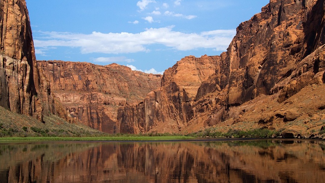 Image of the Colorado River with sandstone cliffs in the background 