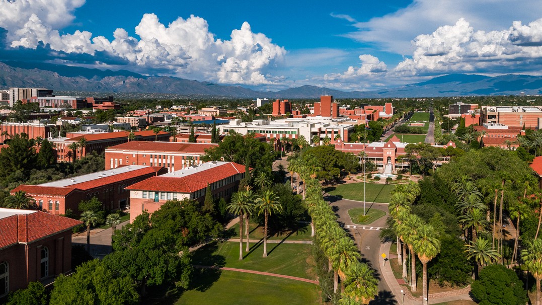 Aerial photo of the U of A campus with the Old Main building in the background under a cloudy sky