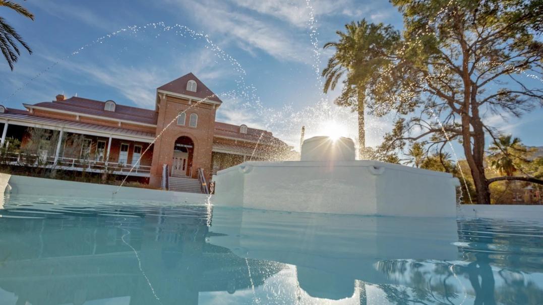Image of the fountain on the U of A campus with Old Min in the background 