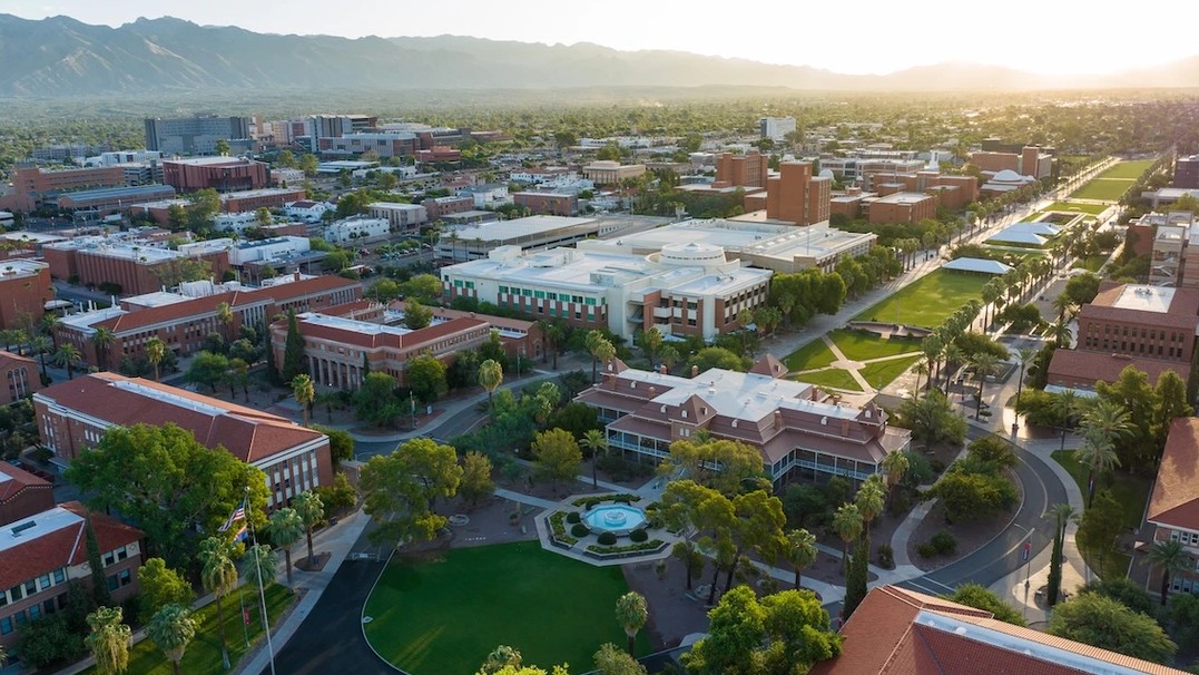 Aerial image of the University of Arizona's campus with mountains in the distance. 