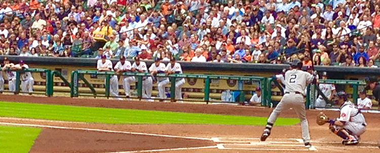Photo of a batter at home plate during a baseball game.