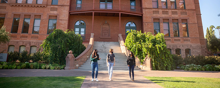 Photo of students interacting outside of ASU's historic Old Main building 