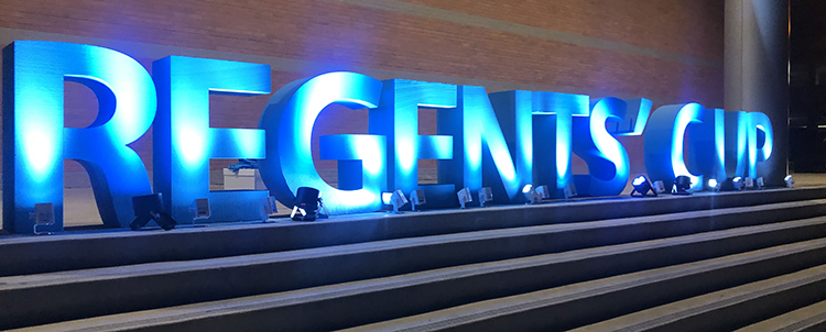 Image of Regents' Cup letters in blue uplit at night 