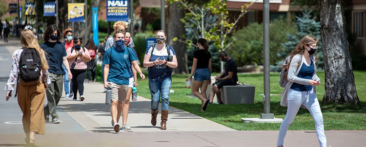 Students walking on campus with facemasks on. 